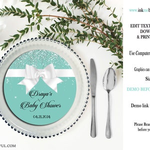 Puede incluir: Un cargador de baby shower de color turquesa y brillo plateado con un lazo blanco y el texto "Draya's Baby Shower 04.21.2024".
