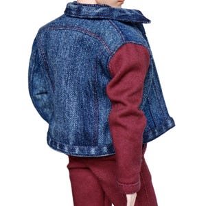 May include: A denim jacket with maroon sleeves and maroon pants. The jacket has a button closure and a collar.