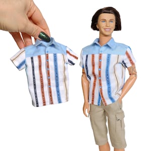 May include: A blue and white striped short-sleeved button-down shirt with brown stripes. The shirt has a collar and a pocket on the left side.
