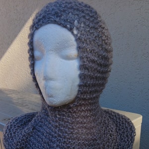 May include: A grey knitted cowl with a hood. The cowl is made from a soft, sparkly yarn.