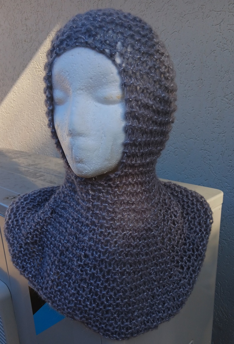 May include: A gray knitted cowl with a hood. The cowl is made of a soft, sparkly yarn.