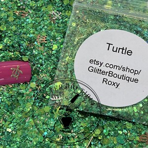 May include: Green glitter with small turtle charms and a label that reads "Turtle etsy.com/shop/GlitterBoutique Roxy".