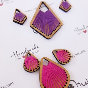 May include: Assortment of handmade wooden earrings with colorful thread embroidery. The earrings are in the shapes of a teardrop and a diamond. The text "Handmade with love for you" is visible on the white background.