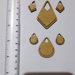 May include: Five wooden shapes with holes around the edges. The shapes are a diamond, two teardrop shapes, and two smaller triangles.