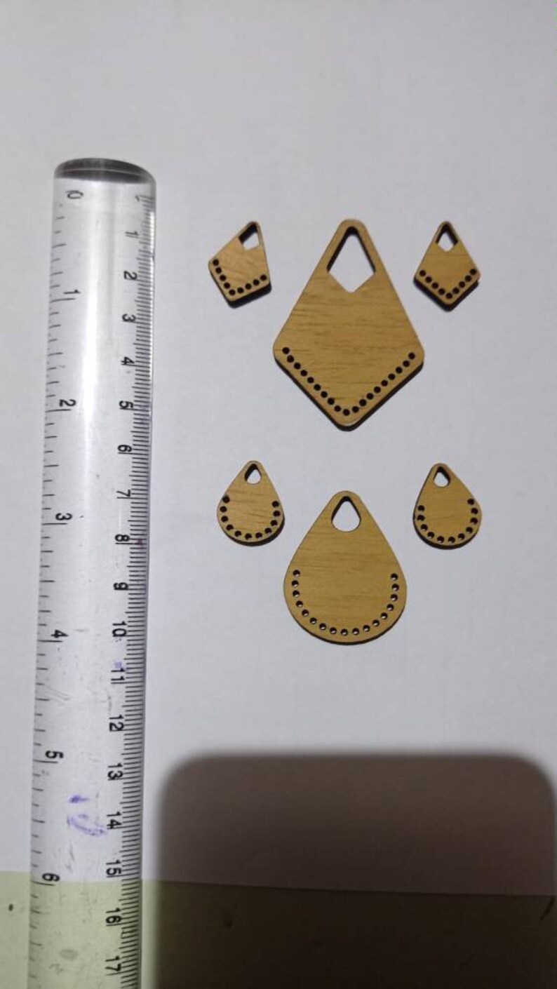 May include: Five wooden shapes with holes around the edges. The shapes are a diamond, two teardrop shapes, and two smaller triangles.