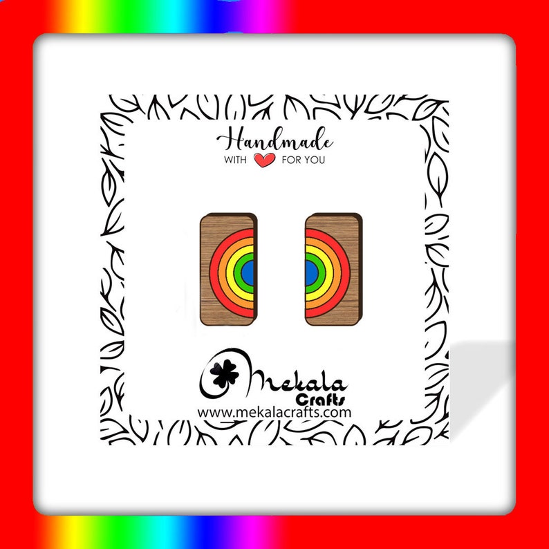 May include: A pair of rainbow wooden earrings with a brown background. The earrings are handmade and feature a rainbow design with red, orange, yellow, green, blue, indigo, and violet colors. The text "Handmade with &hearts; for you" is visible in the image.