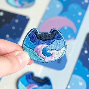 Embroidered iron-on patch of a night cat with moon and blue and purple clouds, perfect for decorating your clothes and tote bags - Sunset Patch