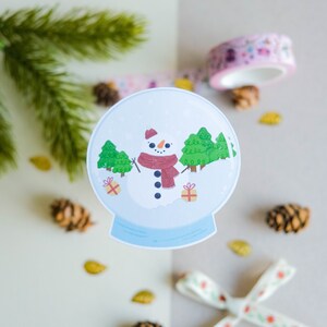 Autocollant Matte Boule à neige avec bonhomme de neige et sapins mignons parfait pour décorer son bullet journal cet Hiver