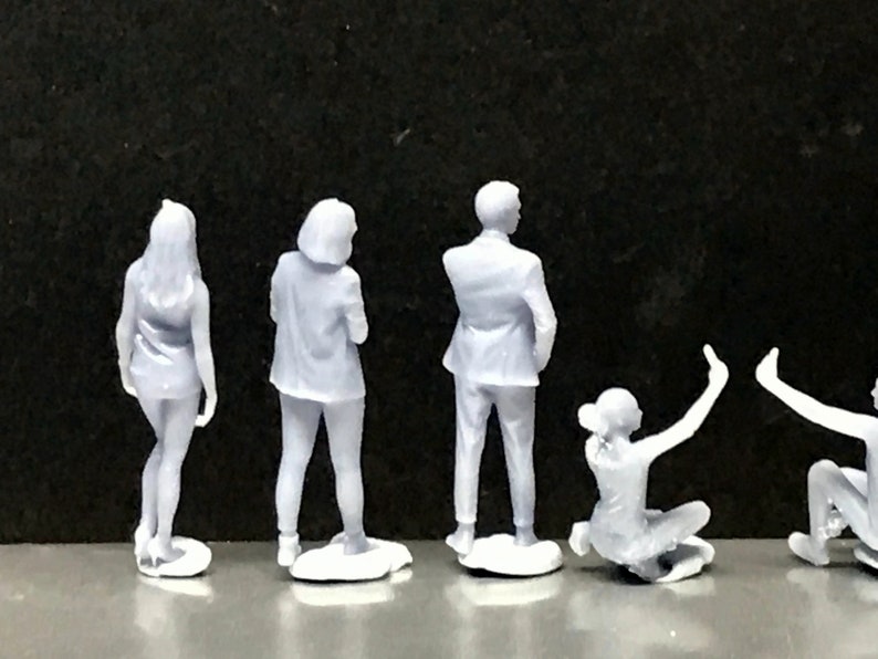 May include: Set of six white plastic figurines of people in various poses. The figurines are about 3 inches tall and are made of a smooth, matte plastic.