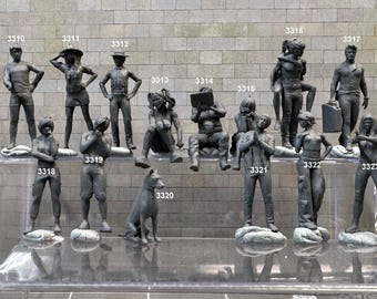 May include: A collection of 15 gray painted figurines, including people and a dog, displayed on a clear shelf. The figurines are numbered 3310 through 3323.