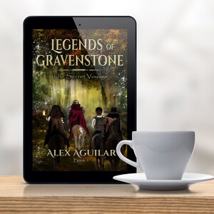 May include: A tablet computer displaying the cover of a fantasy novel titled "Legends of Gravenstone: The Secret Voyage" by Alex Aguilar. The cover features a group of people on horseback riding through a forest.
