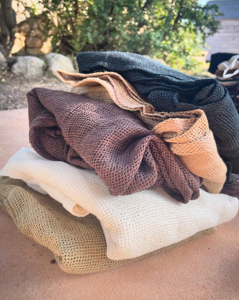 May include: A stack of four crocheted dishcloths in various shades of brown, beige, and black. The cloths are made of a soft, textured material and are perfect for cleaning and drying dishes.