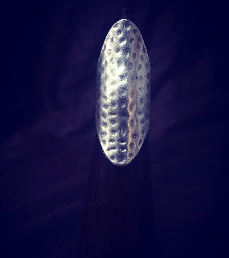 May include: A silver hammered metal ring with a textured surface.
