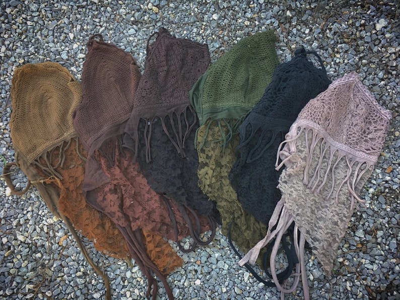 May include: Seven crocheted tops with fringe detailing in various colors, including brown, green, black, and purple.