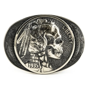 May include: Silver belt buckle with a detailed skull design of a Native American woman's profile. The buckle features the words "Liberty" and "1935".