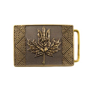 May include: A rectangular, antique brass belt buckle featuring a detailed maple leaf design in the center. The buckle has a textured background and decorative geometric patterns on the edges. The buckle's hardware is a matching brass color.