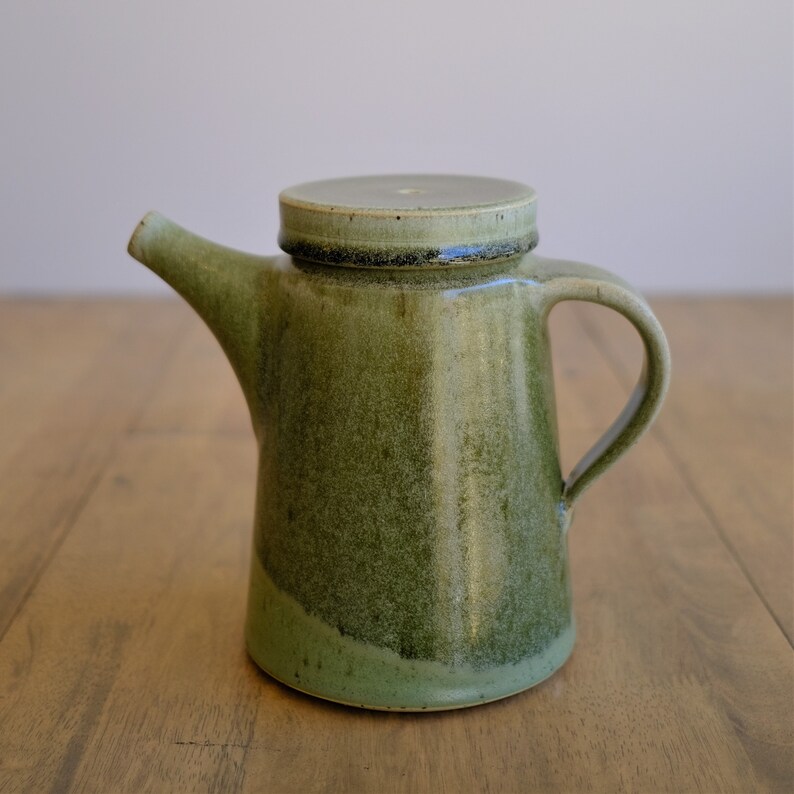Large handmade stoneware teapot holding 32 ounce volume and contemporary style with green glaze.