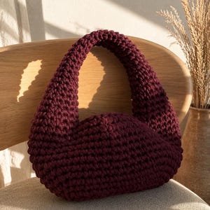 Op de afbeelding: Een set van drie keramische mokken met een gespikkelde, matte afwerking. De mokken zijn in de kleuren crème, lichtgrijs en donkergrijs. Elke mok heeft een eenvoudig, minimalistisch ontwerp en een afgeronde handgreep. De mokken zijn op elkaar gestapeld.