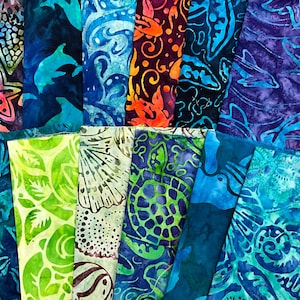May include: A collection of colorful batik fabric pieces. The fabrics feature various marine life and nature-inspired designs, including starfish, dolphins, and leaves. The color palette includes shades of blue, green, orange, and purple.