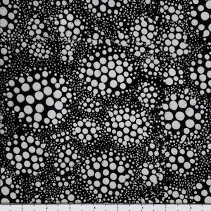May include: Black and white fabric with a pattern of white circles of varying sizes. The circles are scattered randomly across the fabric, creating a dynamic and abstract design.