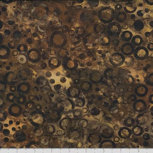 May include: Brown fabric with a pattern of black circles and rings. The circles and rings are of varying sizes and are randomly placed on the fabric.