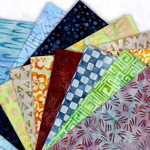 May include: A fan of colorful fabric swatches with various patterns. The fabrics display designs in shades of blue, green, orange, and red. Patterns include dots, geometric shapes, and organic motifs. Ideal for quilting or craft projects.