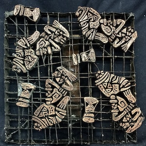 May include: A set of six wooden printing blocks with intricate geometric designs, arranged on a metal grid. The blocks are a light brown color and have a worn, antique appearance.