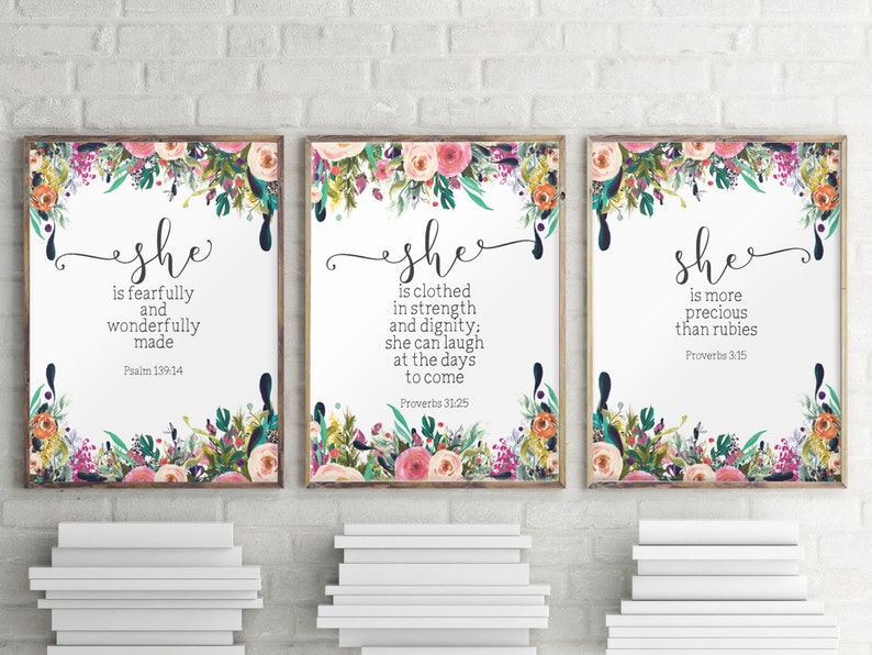 Puede incluir: Tres impresiones enmarcadas con bordes florales y fondos blancos. Cada impresi&oacute;n presenta la palabra "ella" en una fuente decorativa y un vers&iacute;culo b&iacute;blico. La primera impresi&oacute;n dice "ella es hecha de manera temible y maravillosa" con el vers&iacute;culo "Salmo 139:14". La segunda impresi&oacute;n dice "ella est&aacute; vestida de fuerza y dignidad; ella puede re&iacute;rse de los d&iacute;as venideros" con el vers&iacute;culo "Proverbios 31:25". La tercera impresi&oacute;n dice "ella es m&aacute;s preciosa que los rub&iacute;es" con el vers&iacute;culo "Proverbios 3:15".
