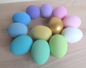 May include: A collection of ten Easter eggs in various pastel colors, including light blue, pink, yellow, and green. The eggs are arranged in a circle on a wooden surface.