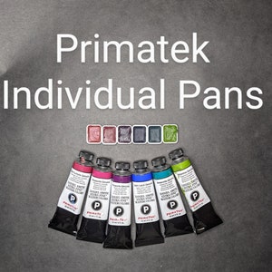 May include: An assortment of Primatek Individual Pans and tubes of Daniel Smith Extra Fine Watercolors. The image displays a variety of colors, including pink, purple, blue, and green, against a dark gray background. The text "Primatek Individual Pans" is at the top.
