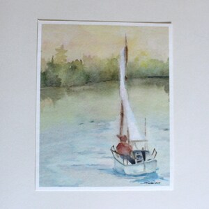 May include: Watercolor painting of a sailboat on a lake with a person in the boat. The sky is a soft yellow and the water is a light blue. The trees on the shore are a dark green.