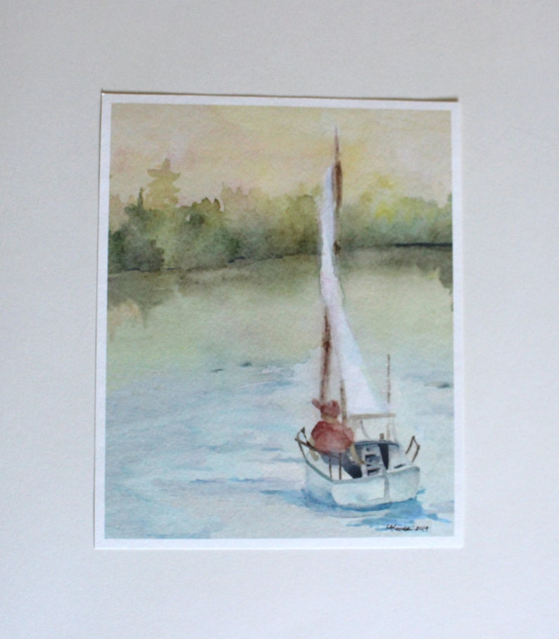 May include: Watercolor painting of a sailboat on a lake with a person in the boat. The sky is a soft yellow and the water is a light blue. The trees on the shore are a dark green.