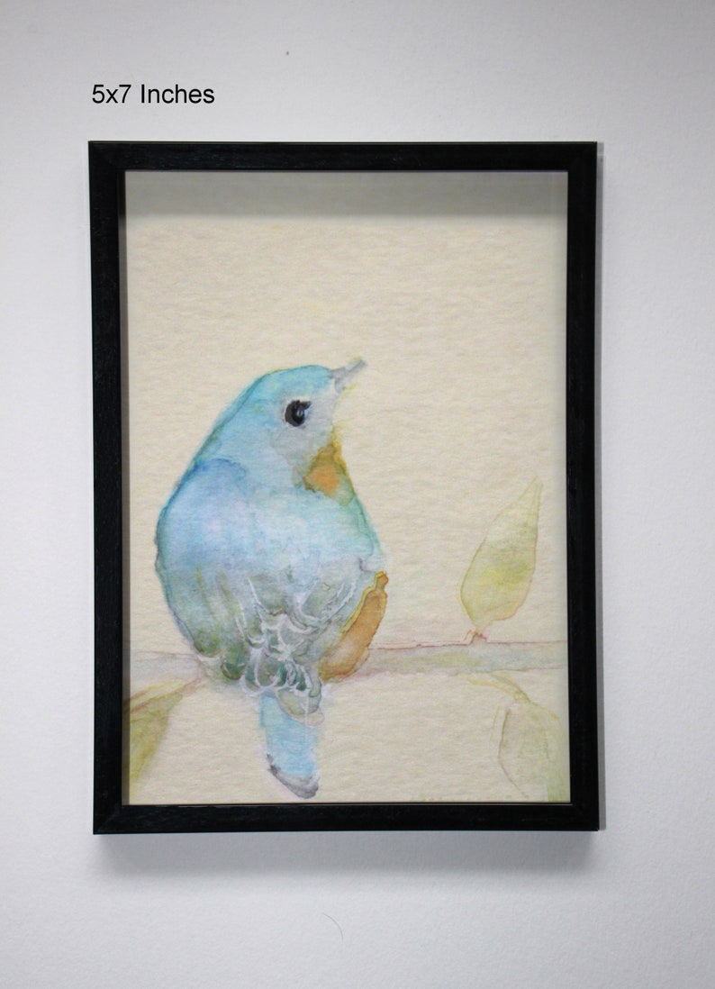 K&ouml;nnte beinhalten: Ein Aquarellbild eines blauen Vogels, der auf einem Zweig mit gr&uuml;nen Bl&auml;ttern sitzt. Das Bild ist in einem schwarzen Rahmen gerahmt und misst 12,7 x 17,8 cm.