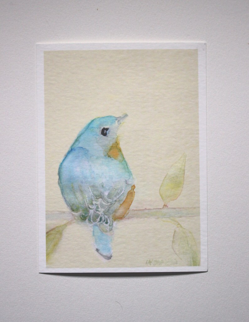 K&ouml;nnte beinhalten: Ein Aquarellbild eines blauen Vogels, der auf einem Ast mit gr&uuml;nen Bl&auml;ttern sitzt. Der Vogel ist nach rechts gewandt und hat einen hellblauen K&ouml;rper mit einem dunkelblauen Kopf und Schwanz. Der Hintergrund ist hellgelb.