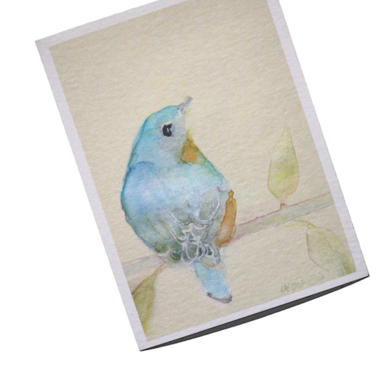 Minimalist watercolor of a charming bluebird sitting on a branch is the focus for this art print on textured, acid free paper.  The songbird is painted in blue, orange and light grey.  The background is a pale warm yellow.  Evokes a feeling of  peace