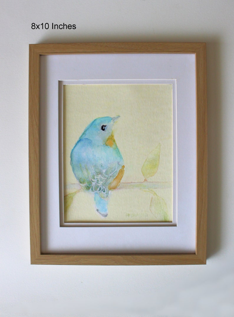K&ouml;nnte beinhalten: Ein gerahmtes Aquarellbild eines blauen Vogels, der auf einem Zweig mit gr&uuml;nen Bl&auml;ttern sitzt. Das Bild ist vor einem gelben Hintergrund platziert und in einem hellen Holzrahmen gerahmt. Der Rahmen ist 20,32 x 25,4 cm gro&szlig;.