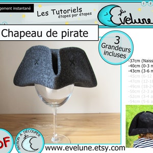 May include: A gray pirate hat with a patterned design, displayed on a wine glass. The hat has a curved brim and is decorated with two small black crosses. The image includes the text "Chapeau de pirate".
