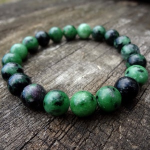 May include: A green and black gemstone bracelet with round beads. The bracelet is made of natural stones and is a beautiful piece of jewellery.