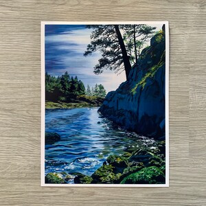 May include: A painting of a rocky shoreline with a small inlet of blue water. The water is calm and reflects the sky, which is a light blue with white clouds. There are trees on the left side of the image and a large rock face on the right side.