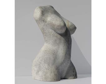 May include: A white marble sculpture of a torso. The sculpture is smooth and has a slightly textured surface.