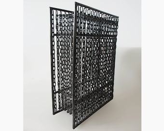 May include: A black metal sculpture made of interconnected chains, forming a rectangular shape. The sculpture is composed of multiple layers of chains, creating a three-dimensional effect.