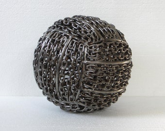 May include: A silver metal sphere sculpture made entirely of linked chains.