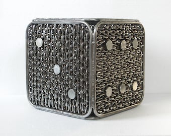 May include: A cube-shaped metal container made of interwoven chains with circular metal accents. The container is a decorative piece with a unique design.