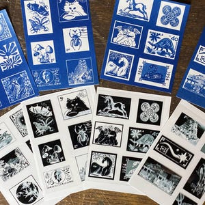 May include: A collection of eight rectangular sheets featuring grid layouts of postage stamp designs. Four sheets are printed in blue ink on white paper, and four are printed in black ink on white paper. Each sheet displays various illustrations.