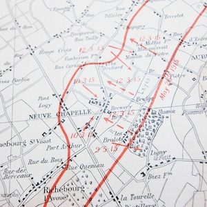 May include: A vintage map of a region in France, showing the location of towns and villages, with red lines indicating the path of a military advance. The map is dated May 26, 1915.