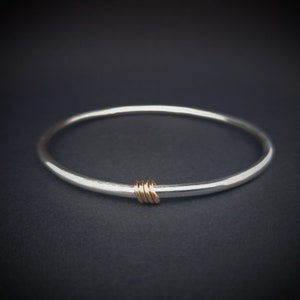 Sterling silver bangle with 9 carat rose gold rings