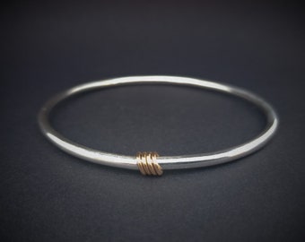 Sterling silver bangle with 9 carat rose gold rings