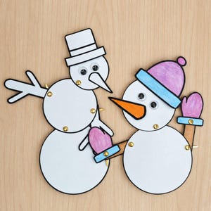 Peut inclure: Deux figurines de bonhommes de neige en papier articulées, assemblées par des attaches parisiennes dorées. L'un porte un haut-de-forme blanc, l'autre un bonnet violet et bleu avec des moufles roses. Ils ont des yeux mobiles et un nez orange.