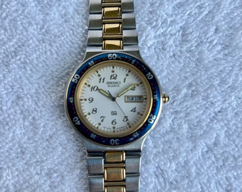 Vintage Seiko Blue Bezel Day Date English & Spanish Gold and Steel Quartz Japan Watch