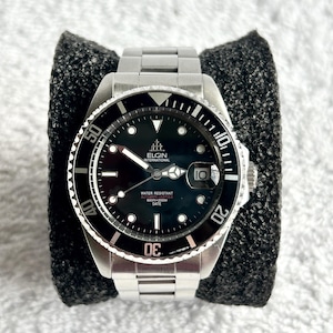 May include: A black and silver men's wristwatch with a black face and silver hands. The watch has a rotating bezel with numbers from 0 to 60. The watch face has the words "ELGIN INTERNATIONAL" and "WATER RESISTANT AUTOMATIC DEEPSEA 860ft/200M DATE".